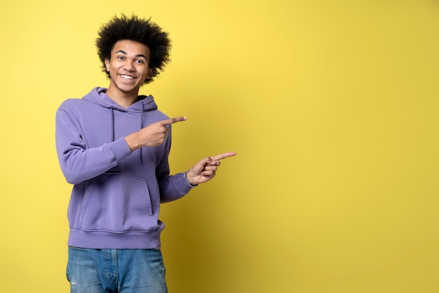 Homem afro-americano feliz isolado no fundo, apontando os dedos no espaço da cópia. compras, vendas