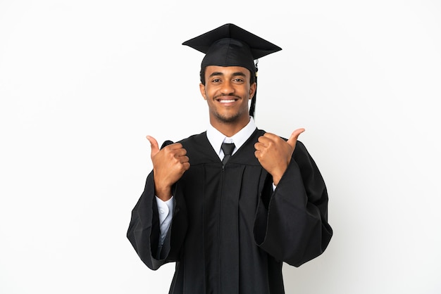 Homem afro-americano graduado em universidade sobre fundo branco isolado com gesto de polegar para cima e sorriso