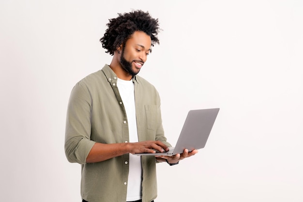 Homem afro-americano moderno confiante de 30 anos usando laptop isolado em empreendedor homem branco digitando
