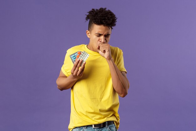 Homem afro-americano novo na camisa amarela que mostra o gesto.