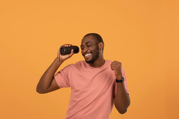 Foto homem afro-americano ouvindo música no alto-falante