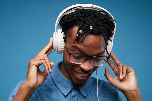 Homem afro-americano, ouvindo música no azul