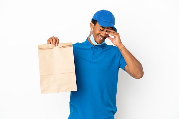 Homem afro-americano pegando uma sacola de comida para viagem isolada no fundo branco rindo