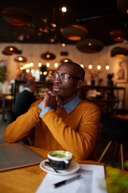 Homem afro-americano pensativo no café