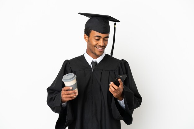 Homem afro-americano universitário sobre fundo branco isolado segurando café para levar e um celular