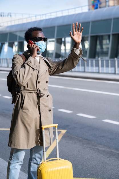 Homem afro-americano usando máscara no aeroporto