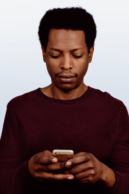 Homem afro-americano, usando seu telefone.