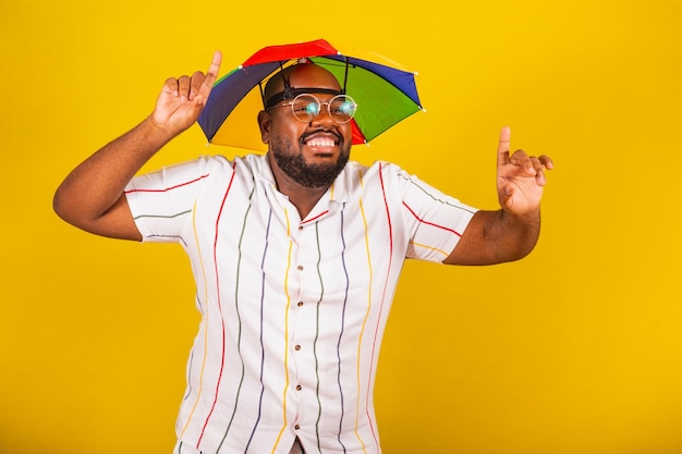 Homem afro brasileiro bonito vestido para o carnaval festa típica brasileira folia de carnaval festejando Sinal escolhido dedo levantado eu me escolho dançando alegre festejando se divertindo