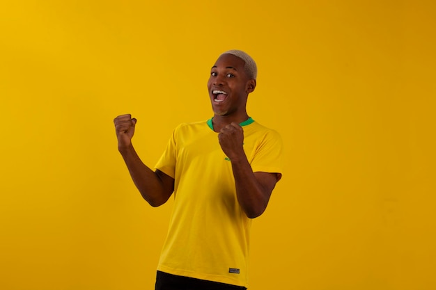 Homem afro brasileiro com a camisa do time de futebol brasilia para a copa 2022 no qatar