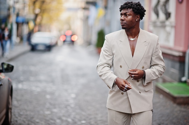 Homem afro elegante terno bege da velha escola. Na moda jovem Africano masculino em jaqueta casual no torso nu.