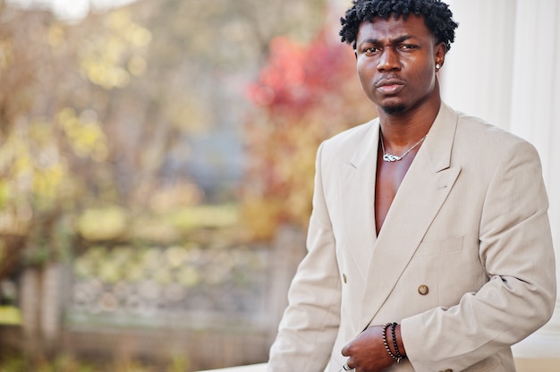 Homem afro elegante terno bege da velha escola. Na moda jovem Africano masculino em jaqueta casual no torso nu.
