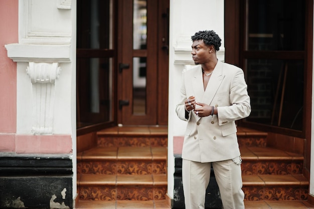 Homem afro estiloso em terno bege da velha escola Homem africano na moda em jaqueta casual no torso nu