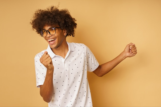 Homem afro feliz com óculos dançando música