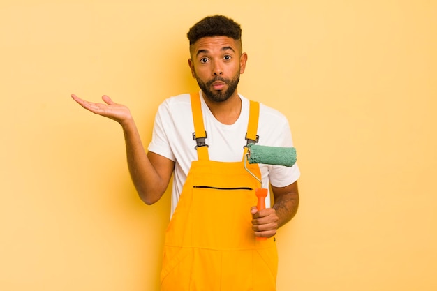 Homem afro negro se sentindo confuso e confuso e duvidando do conceito de pintura em casa