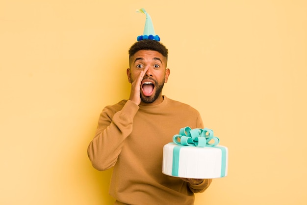 Homem afro negro se sentindo feliz dando um grande grito com as mãos ao lado do conceito de aniversário da boca