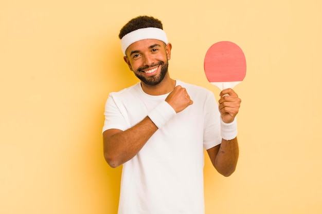 Homem afro negro se sentindo feliz e enfrentando um desafio ou celebrando o conceito de pingue-pongue