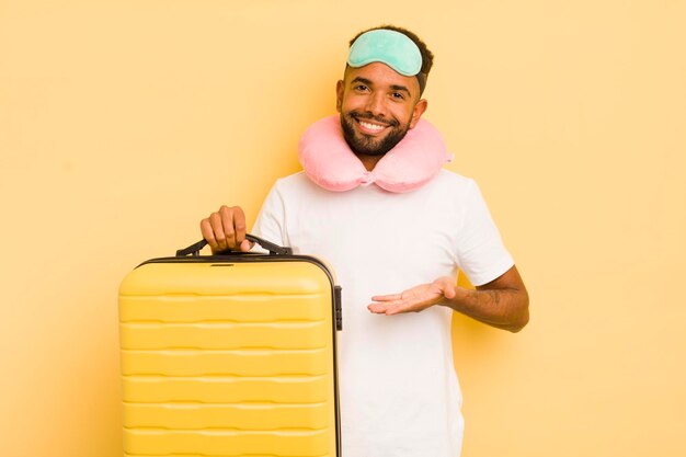 Homem afro negro sorrindo alegremente se sentindo feliz e mostrando um conceito de conceito de voo de passageiros