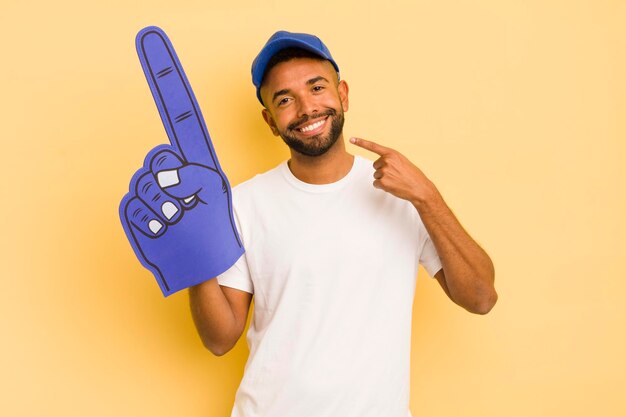 Homem afro negro sorrindo com confiança apontando para o próprio sorriso largo conceito de mão número um conceito de mão número um