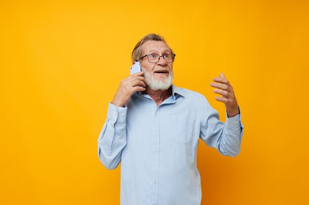 Foto homem alegre a falar no telemóvel contra um fundo amarelo