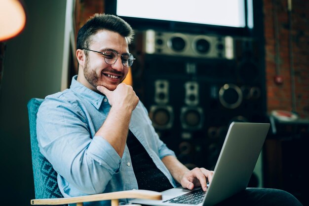 Homem alegre assistindo conteúdo engraçado no laptop