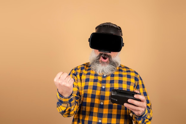 Homem alegre com óculos 3D brincando com um joystick em um fundo amarelo