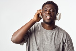 Foto homem alegre de aparência africana em fones de ouvido ouve música