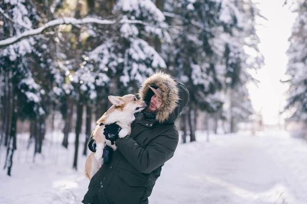 Homem alegre detém um cachorro corgi