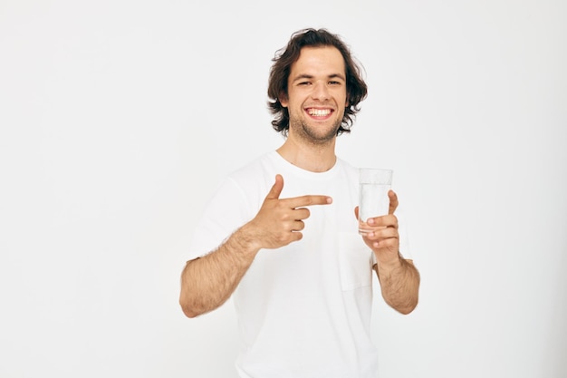 Homem alegre em uma camiseta branca copo de água Estilo de vida inalterado