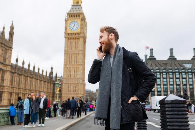 Foto homem alegre falando ao telefone no centro de londres