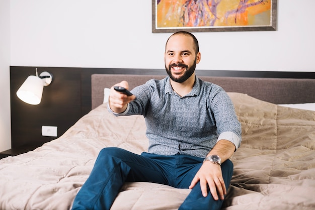 Homem alegre que gosta de um programa de tv