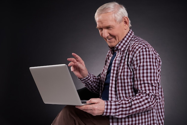 Homem alegre sentado com laptop