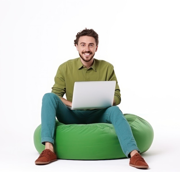 Homem alegre trabalhando em um laptop sentado em um saco de feijão verde