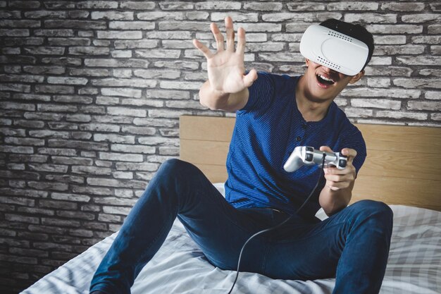 Foto homem alegre usando realidade virtual enquanto está sentado na cama em casa