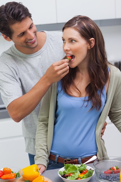 Homem alimentando sua esposa tomate cereja