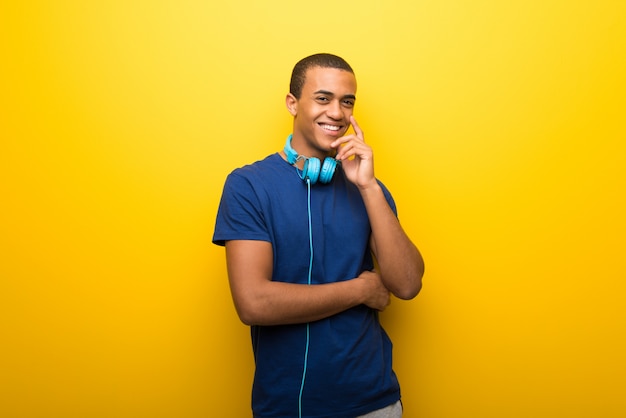 Homem americano africano, com, azul, t-shirt, ligado, experiência amarela, sorrindo, com, um, doce, expressão