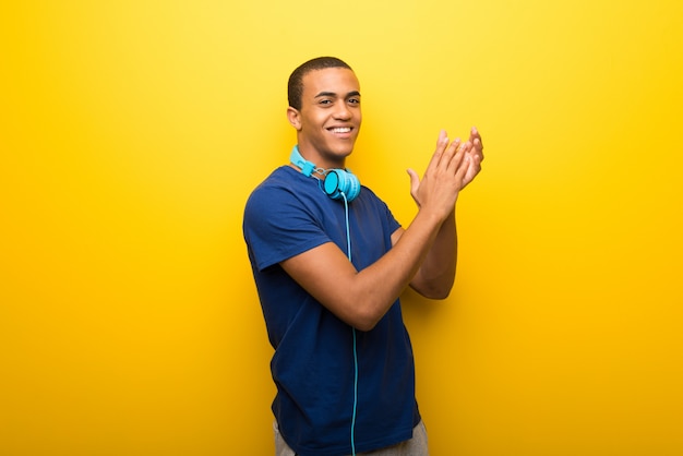 Homem americano africano, com, t-shirt azul, ligado, experiência amarela, aplaudindo, após, apresentação, em, um, conferência