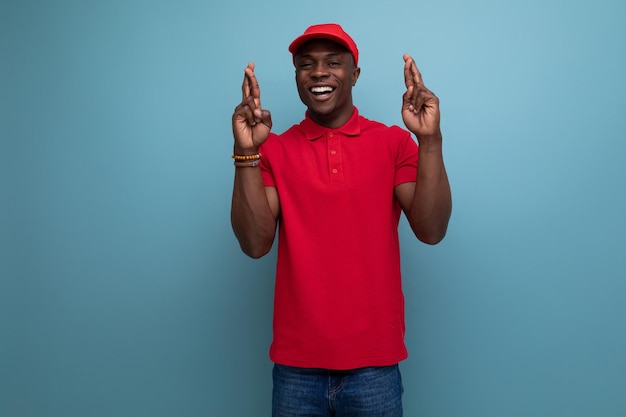 Homem americano jovem trabalhador de entrega em camiseta vermelha e boné de beisebol com maquete de impressão