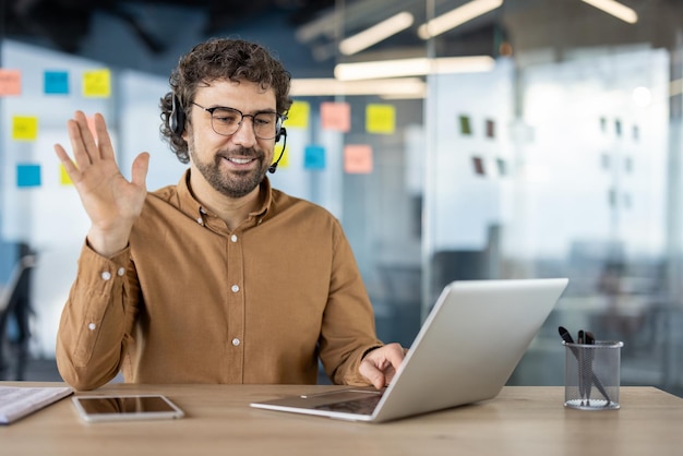 Homem amigável acenando durante uma chamada de vídeo no laptop