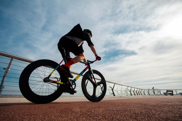 Homem anda de bicicleta na ponteA imagem do ciclista em movimento no fundo pela manhã