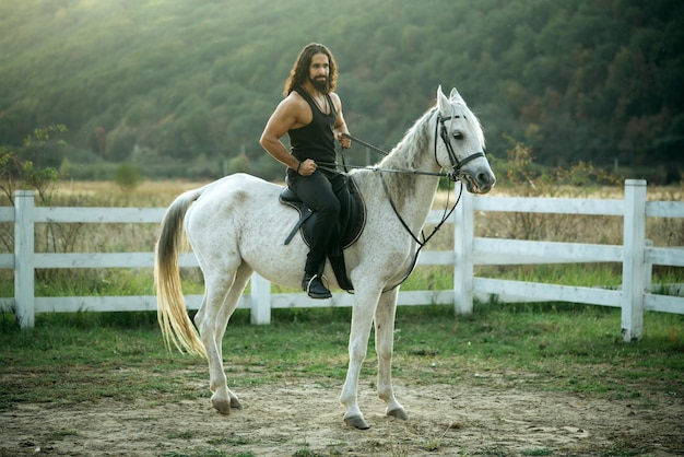 Homem andando a cavalo no campo no verão