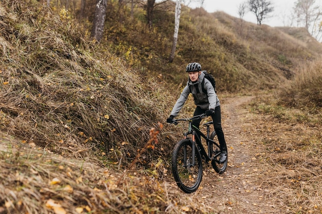 Foto homem andando de bicicleta no caminho da montanha