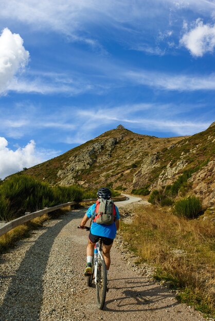 Homem andando de bicicleta viajando nas montanhas