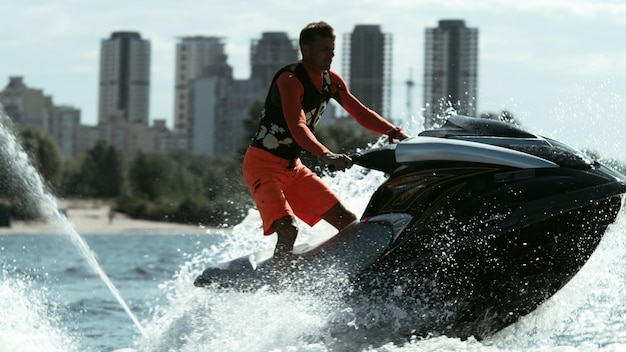 Homem andando de jet ski em câmera lenta piloto masculino em jet ski desportista em jet ski