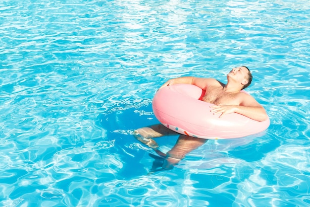 Homem andando na piscina no dia ensolarado sentindo relaxar