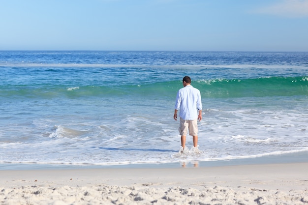 Homem andando na praia