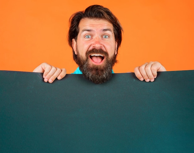 Homem animado com banner de publicidade cara barbudo feliz com espaço de cópia de tabuleiro vazio para texto