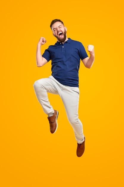 Foto homem animado comemorando o sucesso e pulando alto