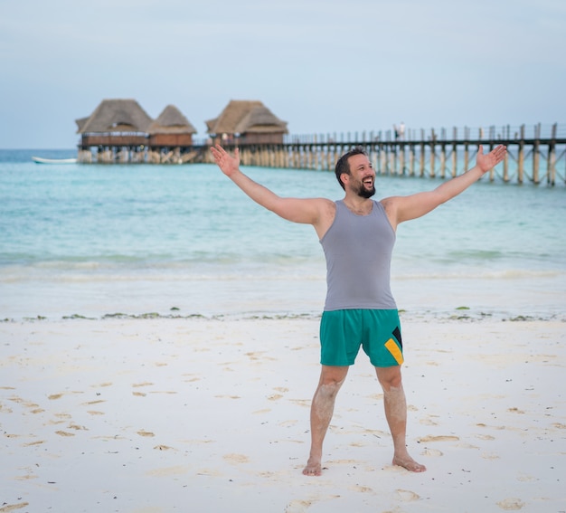 Homem animado feliz na praia tropical