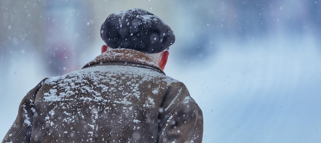 Homem ao ar livre em roupas de inverno durante nevasca e forte nevasca