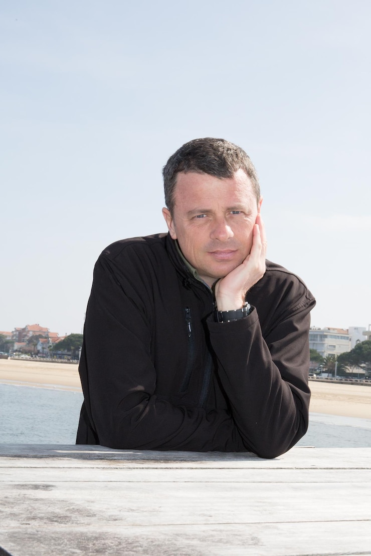 Foto homem ao lado da praia e do mar sorrindo